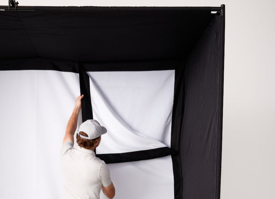 Man putting up high impact screen for SkyTrak Studio enclosure